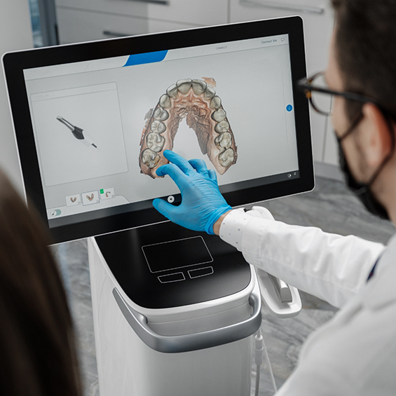 Dentist touching a screen that shows an impression of teeth