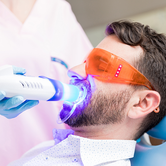 Man getting professional teeth whitening from his dentist
