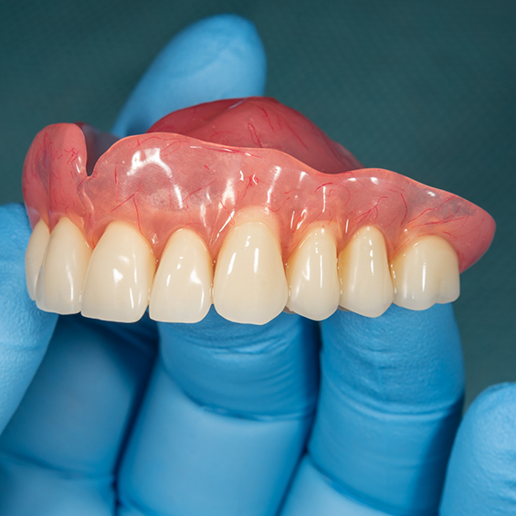 Dentist holding a full denture