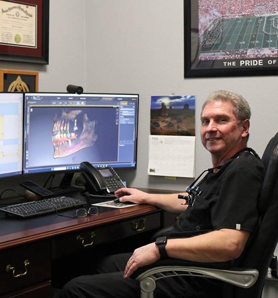 Doctor Hubler sitting at a desk with a computer in a Lucas dental office