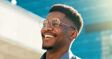 Man in glasses smiling in the sunlight