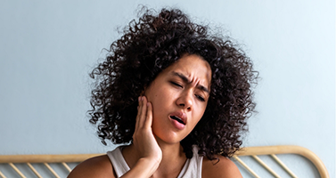 Woman holding the side of her face in pain
