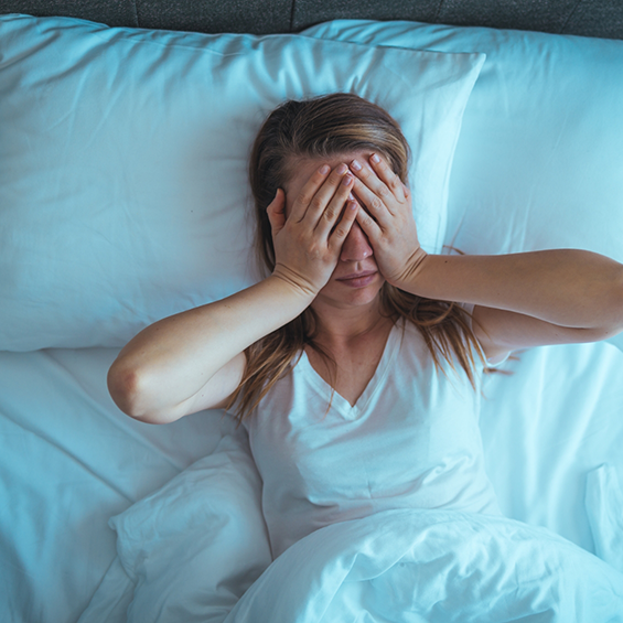 Woman in bed rubbing her eyes