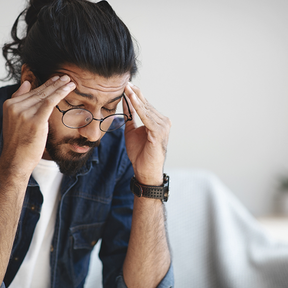 Man rubbing his temples in pain