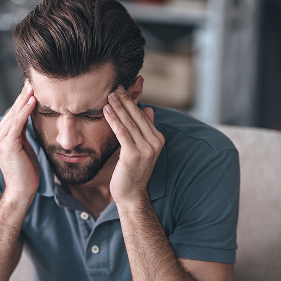Man touching his temples in pain