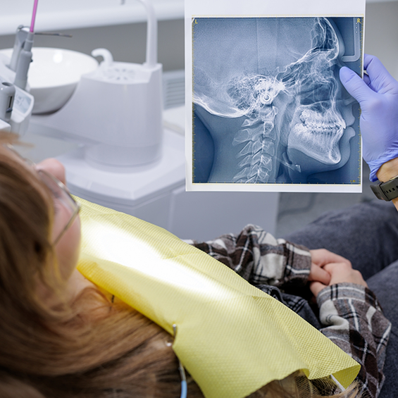Dentist showing a patient an x-ray of their skull