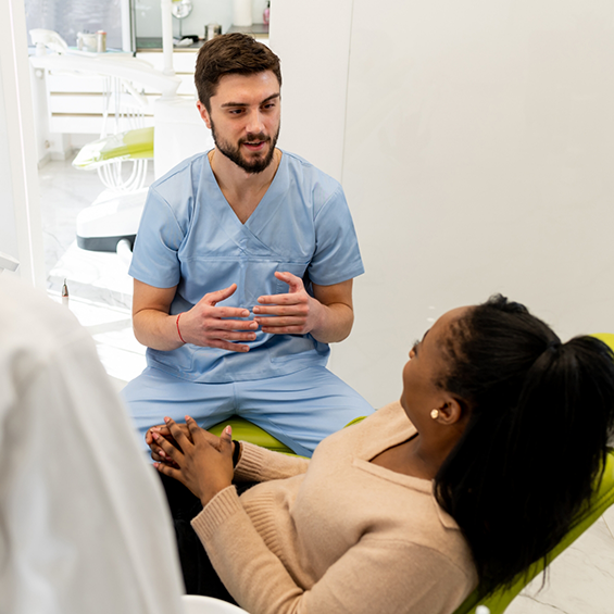 Dentist talking to a patient in the treatment chair