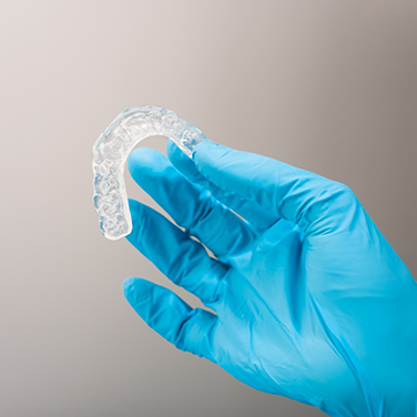 Dentist holding a clear occlusal splint tray